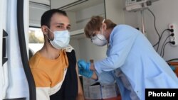 Armenia - A man is vaccinated against coronavirus at a mobile vaccination center in Yerevan, October 24, 2021.