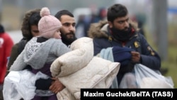 Un grup de migranți, în apropierea centrului de transport și logistică din Bruzgi, de la granița belarusă-polonă. Fotografie realizată la data de 18 noiembrie 2021.