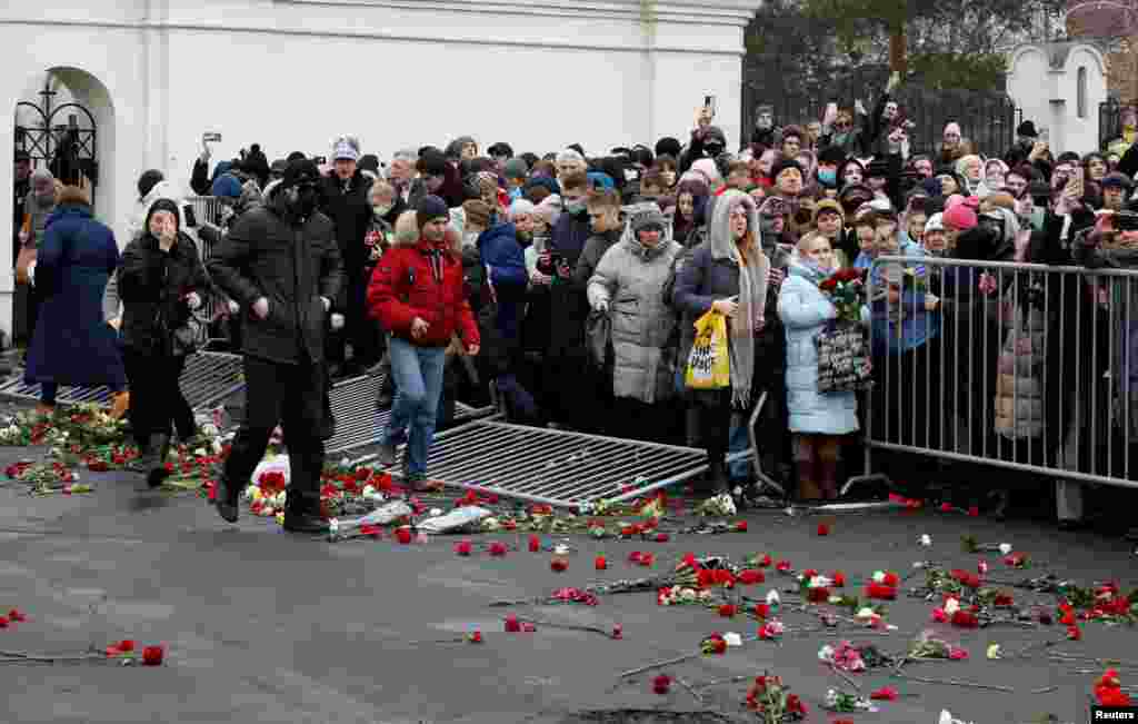 Автомобиль с телом политика забрасывали цветами, люди апплодировали и скандировали "Навальный!" Собравшиеся прорвали ограждения