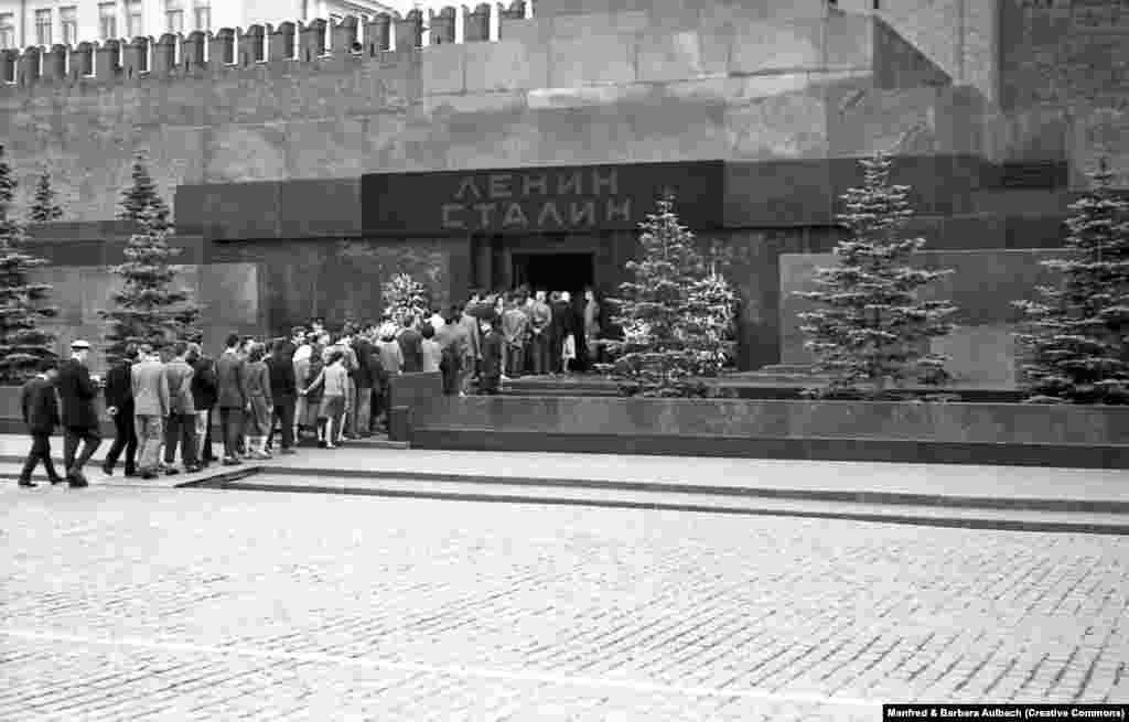 Posjetitelji ulaze u ono što je u augustu 1957. godine postalo Lenjinov i Staljinov mauzolej. Nakon smrti Josifa Staljina 1953. godine, njegovo tijelo je balzamirano i izloženo pored Lenjinovog. Iznad mauzoleja su imena oba sovjetska diktatora.
