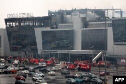 Lucrători ai serviciilor de urgență intervin la sala de concerte Crocus City Hall din Krasnogorsk, în afara Moscovei, pe 23 martie 2024.