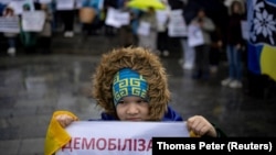Дете държи плакат, на който пише "Демобилизация" по време на протест в Киев срещу удължаването на военната служба и намаляването на възрастта за мобилизация.