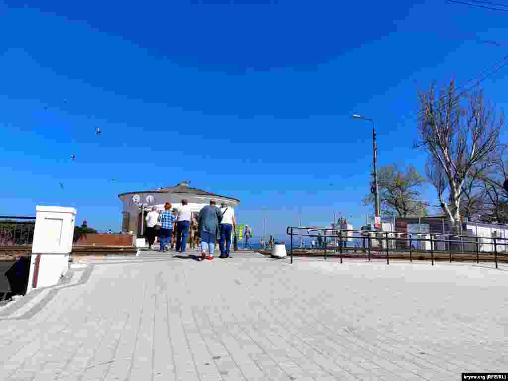 Городская набережная в Феодосии расположена в непосредственной близости от морского порта, но вышедших на прогулку горожан, похоже, такая близость не беспокоит 