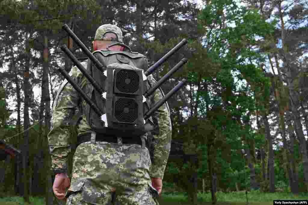 Український військовий з «антидроновим наплічником» на демонстрації засобів глушіння, що відбулася на Львівщині у травні 