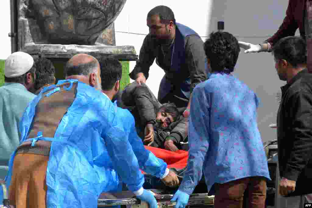 Paramedics place an injured man on a stretcher. The attack, which killed at least 12 people, took place at the office of an independent candidate and former provincial minister, Asfandyar Khan Kakar, officials said, adding that he was not injured in the blast.