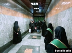 Bărbații de la intrarea în metroul din Teheran verifică respectarea legislației hijabului.