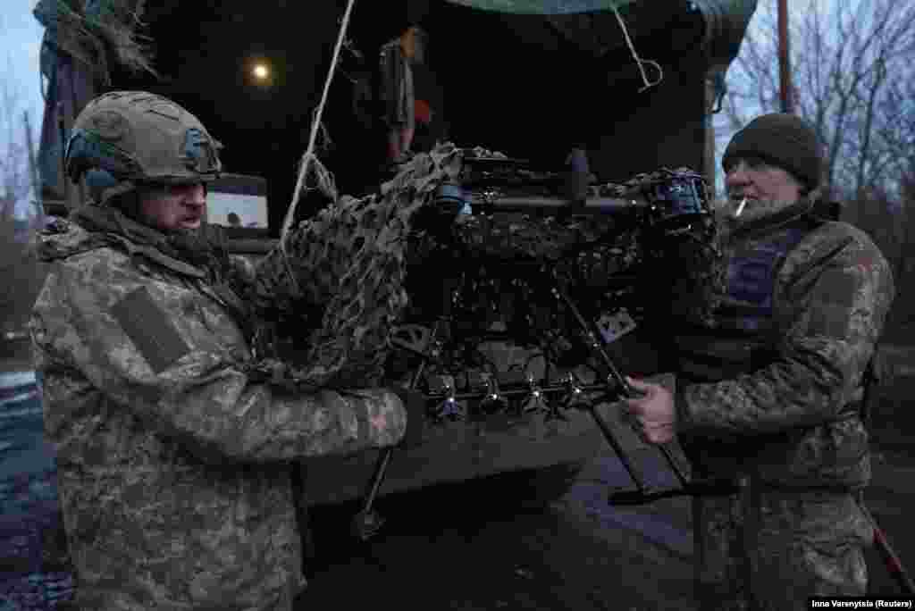 Украински войници от 92-ра бригада "Ахил" разтоварват боен дрон "Вампир" край фронтовия град Бахмут на 1 февруари. Близо две години след пълномащабното нахлуване на Русия в Украйна фронтовата ивица е от около 1200 км. Но движението по фронта до голяма степен е замряло, като и двете страни прибягват до скъпа прецизна артилерия с голям обсег. Те изстрелват крилати ракети и сравнително евтини дронове.