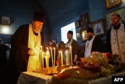 O slujbă bisericească oficiată pentru cei uciși pe 24 ianuarie în satul Iablonovo, în apropiere de locul accidentului.