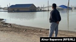 Күлсары шаарынын 4-айылынын тургуну Нурмухан Байжанов чөгүп кеткен үйүн алыстан карап турат. Атырау облусу. 10-апрель, 2024-жыл. 