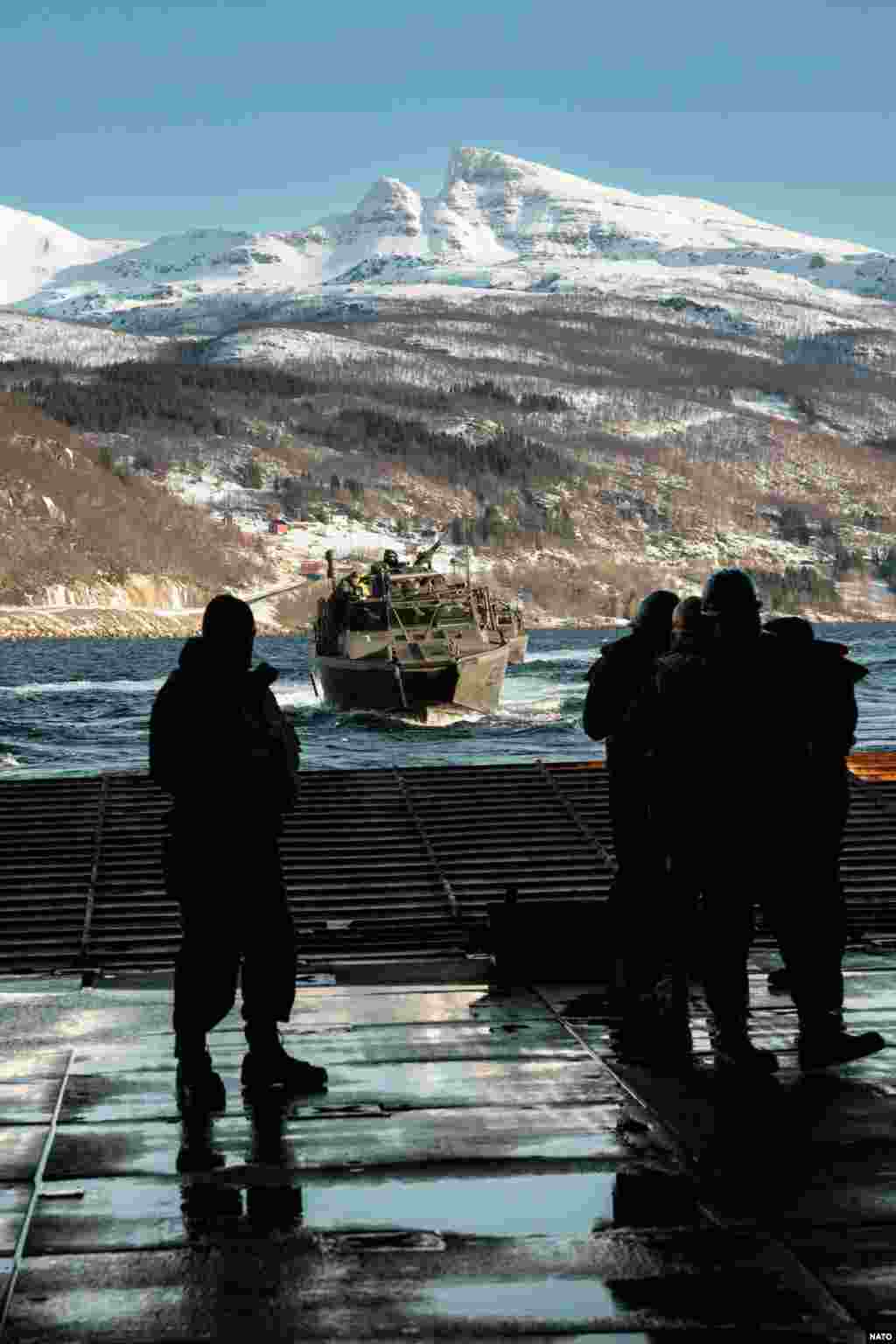 O barcă de asalt suedeză se apropie de o navă de război americană în timpul unui exercițiu din 29 februarie. La sfârșitul anului 2023, Stockholmul și Washingtonul au semnat un acord care oferă acces armatei SUA la bazele suedeze și permite depozitarea armelor și munițiilor în țara nordică. 