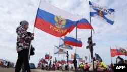 Dijete drži rusku nacionalnu zastavu na "Aleji slave", dijelu groblja gdje su sahranjeni ruski vojnici poginuli u Ukrajini, Sevastopolj, Krim, 24. februar 2024.