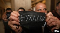Привърженик на Божков държи санитарна маска с надпис "Бухалки".