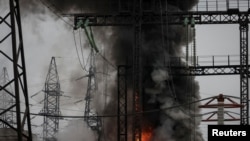 Дим і вогонь біля високовольтної лінії на місці російського ракетного удару під час атаки України поблизу Харкова, 22 березня 2024 року