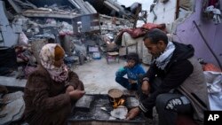 Palestinska porodica ispred svog uništenog doma u izraelskim vazdušnim napadima u Rafi, Pojas Gaze, ponedeljak, 18. mart 2024.