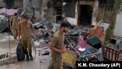 Police officers walk through the rubble of homes vandalized by a Muslim mob in a Christian area in Jaranwala, Faisalabad district, Pakistan, on August 17.