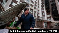 Жител на Буча, сниман в двора на опожарен жилищен блок на 1 март 2022 г.