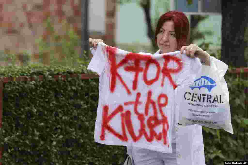 Žena drži majicu sa natpisom &quot;KFOR, ubica&quot;, na protestu ispred zgrade Opštine u mestu Zvečan, na severu Kosova, u sredu, 31. maja 2023. godine.