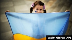 Fetiță ucraineană la un miting organizat în București, în care refugiații cereau liderilor mondiali să condamne agresiunea Rusiei. 