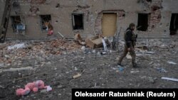 Український військовий біля зруйнованої будівлі в прифронтовому місті Часів Яр Донецької області, Україна, 5 березня 2024 року
