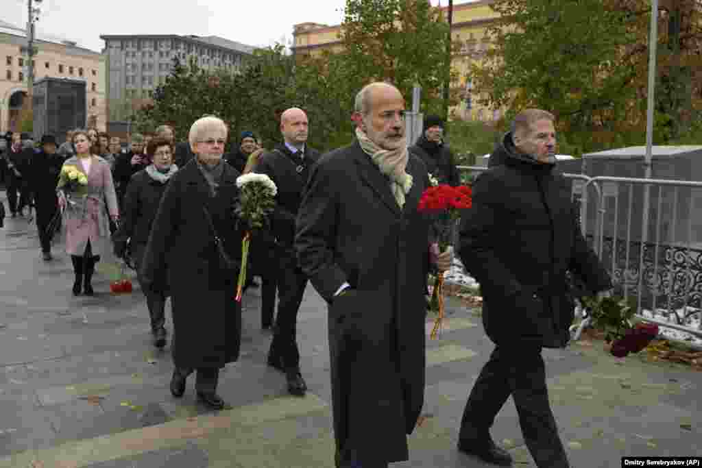 In Moscow, members of diplomatic missions carry flowers to a monument near the Federal Security Service building on the eve of Russia's Remembrance Day for the Victims of Political Repression. The ceremony was held at the Solovetsky Stone monument, a large boulder from the Solovetsky Islands, where the first camp of the gulag political-prison system was located. The October 29 event came amid a Kremlin crackdown on dissent more than 20 months after Russia's full-scale invasion of Ukraine. 