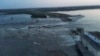 Кадр із відео наслідків руйнування дамби Каховської ГЕС, опублікованого 6 червня 2023 року президентом Зеленським. Влада Уrраїни звинуватила російську армію у підриві машинного залу гідроелектростанції зсередини. Натомість окупаційна адміністрація звинувачує ЗСУ