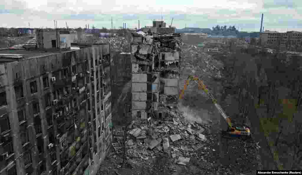 Bager ruši srušeni stambeni blok u Mariupolju 15. februara 2023. Ova fotografija i narednih šest slika koje je napravio fotograf Aleksandar Ermočenko snimljene su od početka do sredine februara 2023, ali ih je Rojters objavio 22. februara.