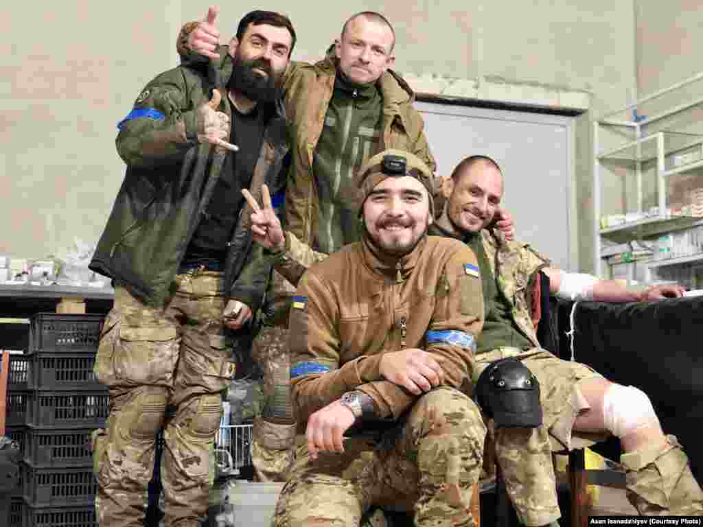 Мариуполь, 2022 год. В центре на этом снимке – крымчанин, боевой медик Асан Исенаджиев, предоставивший Радіо Свобода эти фотографии. Он вышел с «Азовстали» в мае 2022 года с последними украинскими подразделениями, которые оставались на окруженном российскими войсками заводе. После этого он вместе с другими бойцами был заключен в колонии в Еленовке и выжил во время подрыва барака с пленными. 31 декабря 2022 года Асана обменяли. С ним на этой фотографии позируют бойцы «Вишня», «Шпрот» и «Грян» (слева направо). Они прорвались в окруженный Мариуполь на вертолетах. Из них троих в живых остался только «Вишня» – он также прошел российский плен, а после обмена вернулся в армию. «Шпрот» и «Грян» погибли в Мариуполе весной 2022 года