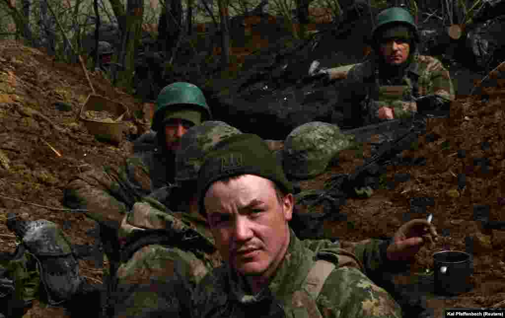 Дощова і холодна погода початку квітня перетворила окопи на рови, заповнені рідкою грязюкою. Попри це, щільний артилерійській вогонь супротивника примушує українських бійців «зариватися під землю». Коротка мить, щоб перевести дух і перекурити. Позиції ЗСУ під Бахмутом, 5 квітня 2023 року