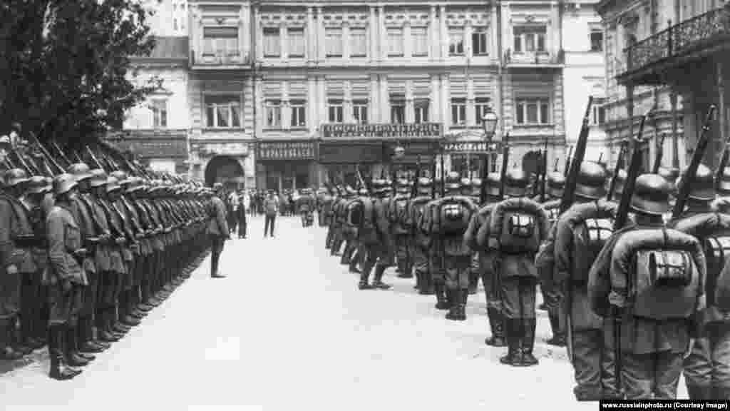 Njemački vojnici na kijevskom trgu Majdan, najvjerovatnije u martu 1918. Nakon revolucije 1917. Koja je dovela Lenjinove boljševike nav last, Rusija je izašla iz Prvog svjetskog rata, ali formalni pregovori o mirovnom sporazumu sa centralnim silama nisu uspjeli. Njemačka, Austro-Ugarska i njihovi saveznici tada su jurišali preko većeg dijela današnje Ukrajine u ofanzivi nazvanoj Operacija Udar šakom prije nego što su novi komunistički lideri Rusije konačno pristali na skupi mirovni sporazum.