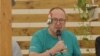 Poslanik Fidesa Žolt Nemet sa papirnim "zavojem" preko uha na festivalu Tusvanjos u istočnoj Transilvaniji, 24. jul 2024.