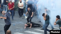 Armenia - A protester is injured by a stun grenade thrown by riot police, Yerevan, June 12, 2024.