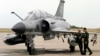 Piloții francezi stau lângă un avion de luptă Mirage. 