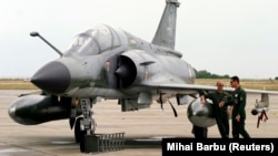 Piloții francezi stau lângă un avion de luptă Mirage. 