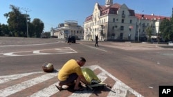 Чоловік прикриває тіло загиблої людини після російської атаки на Чернігів, 19 серпня 2023 року