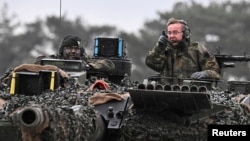 German Defense Minister Boris Pistorius rides in a tank as he visits Leopard II tanks that are due to be supplied to Ukraine at the tank brigade Lipperland of Germany's army in Augustdorf, Germany.