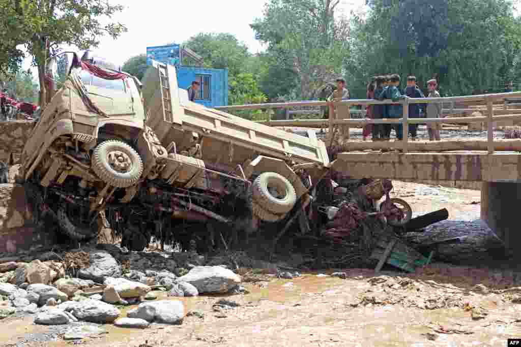 Afghan boys look at a truck that was hit by the floods in the province's Jalrez district. Shafiullah Rahimi, a spokesman for the Taliban's Ministry of Disaster Management, said on July 23 that at least 41 people were missing and at least 74 people were injured.