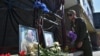 Мъж поднася цветя пред снимките на Евгени Пригожин и Дмитрий Уткин, поставени пред местния офис на паравоенната групировка "Вагнер" в Новосибирск. Твърди се, че двамата са загинали в самолетна катастрофа в сряда.