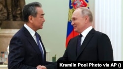 Ruski predsjednik Vladimir Putin (desno) pozdravlja kineskog šefa inostrane politike Vang Jija u Kremlju u Moskvi 22. februara. 2023.