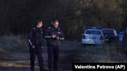 Polițiștii bulgari supraveghează locul unde a fost găsit un camion abandonat în care se aflau cadavrele a 18 imigranți.