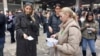 Aktivisti i studenti dele okupljenima listiće sa kontaktima Ministarstva državne uprave i lokalne samouprave kako bi ih prisutni zvali povodom otvaranja biračkih spiskova, 27.12.2023. 