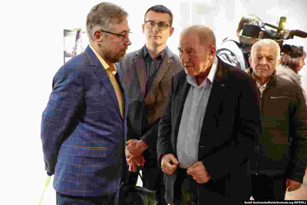 Журналист проекта «Новости Приазовья» Александр Янковский, и заместитель главы Меджлиса крымскотатарского народа Ильми Умеров общаются на фотовыставке