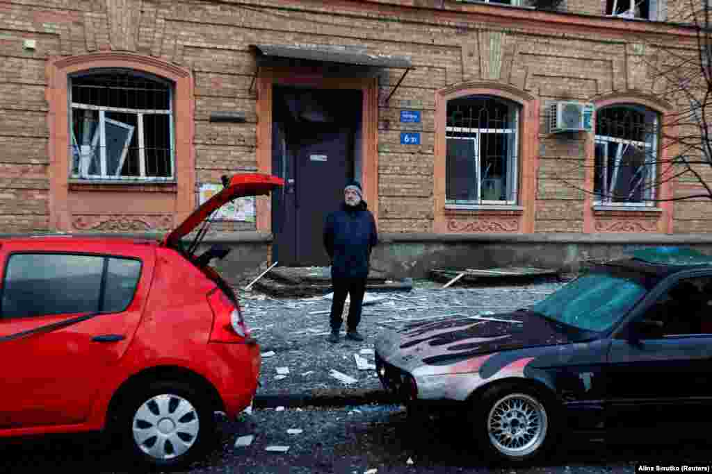 Чоловік стоїть біля пошкоджених автомобілів. Київ, 21 березня 2024 року. «Після 44-денної паузи ворог знову завдав ракетного удару по Києву, – сказав Сергій Попко, голова КМВА. – На місцях працюють усі екстрені служби. Триває ліквідація наслідків ракетного обстрілу»