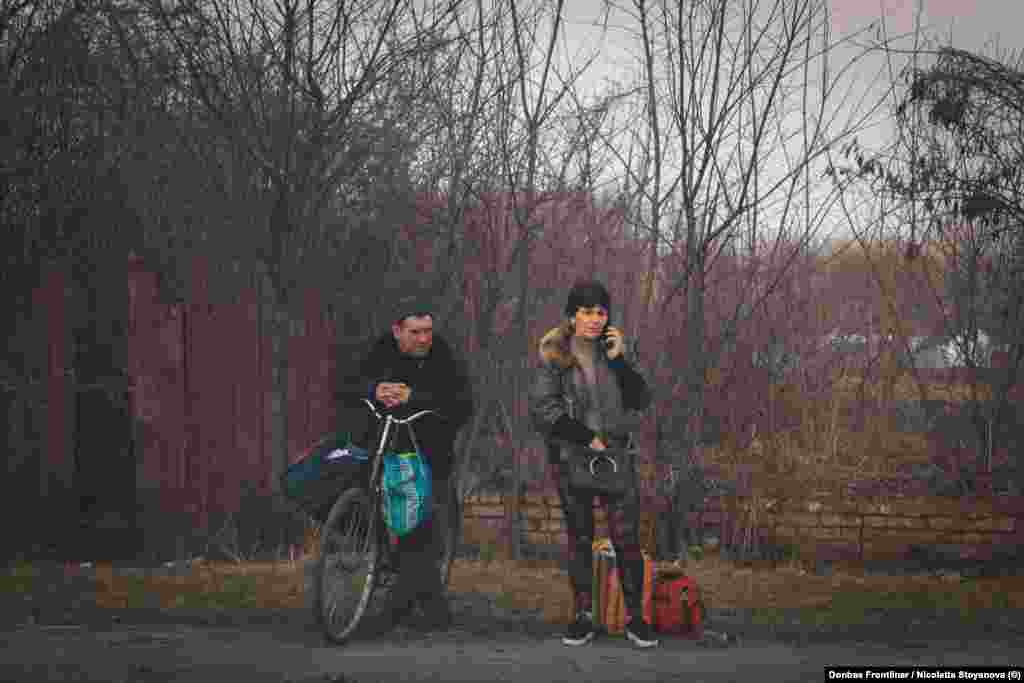 Locuitorii din zonă așteaptă în timpul unei pauze între bombardamente să fie evacuați. 
