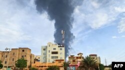 په خرطوم کې د ودانیو شا ته تر جګړې وروسته له یو ځایه لوګی خېژي - د جون نهمې انځور. 