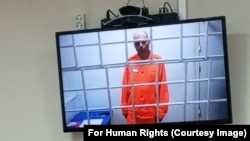 Vladimir Kara-Murza este prezentat pe un ecran video din închisoarea sa din Omsk, la o audiere din iunie, la care a cerut permisiunea de a vorbi cu soția sa la aniversarea a 20 de ani de căsătorie.