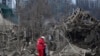 Медпрацівник заспокоює жінку посеред руїн будинків у Запоріжжі. Наслідки російської ракетної атаки. 22 березня 2024 року