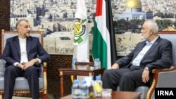 Iranian Foreign Minister Hossein Amirabdollahian (left) meets with the leader of the Palestinian militant group Hamas, Ismail Haniyeh, in Doha on October 13.