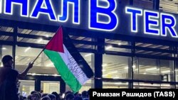 Махачкала аэропортундагы демонстранттар көтөрүп чыккан Палестинанын желеги. 