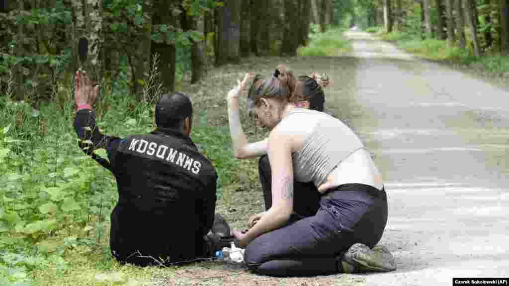 Poljska aktivistica pruža pomoć alžirskom migrantu koji je stigao na teritoriju Poljske u Bjelovjeskoj šumi. Broj pokušaja ilegalnog prelaska granice iz Bjelorusije u Poljsku, članicu EU, porastao je posljednjih mjeseci na skoro 400 dnevno u odnosu od samo nekoliko po danu ranije ove godine, kažu poljski zvaničnici. 