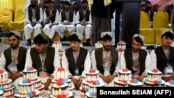 Afghan grooms attend a mass wedding ceremony at a hall in Kandahar, Afghanistan, on February 28.